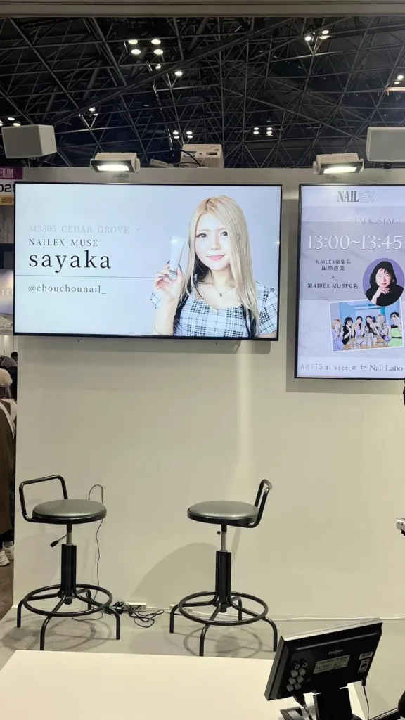 Nail Labo ブースのモニターに映る NAILEX MUSE sayaka の紹介